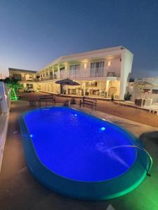 een groot blauw zwembad voor een gebouw bij Pousada Garden in Tramandaí