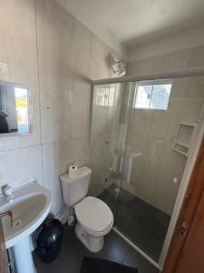 a bathroom with a toilet and a shower and a sink at Pousada Garden in Tramandaí +27 photos
