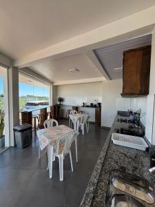 een keuken met een tafel en stoelen in een kamer bij Pousada Garden in Tramandaí +27 foto's