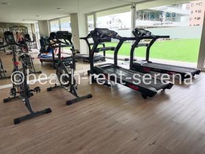 a gym with several tread machines in a room at Beach Rent La Serena in La Serena