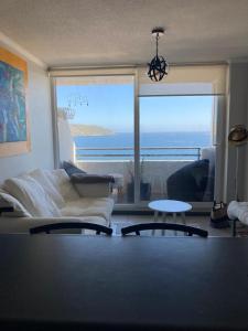 a living room with a couch and a view of the ocean at La Herradura Mágica descansa y disfruta en familia in Coquimbo