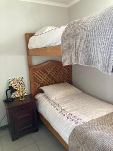 a bedroom with two bunk beds and a night stand at La Herradura Mágica descansa y disfruta en familia in Coquimbo