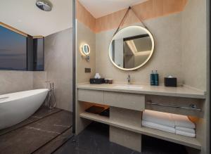 une salle de bain avec une baignoire, un lavabo et un miroir dans l'établissement DoubleTree by Hilton Zhangzhou, à Zhangzhou 26 autres photos