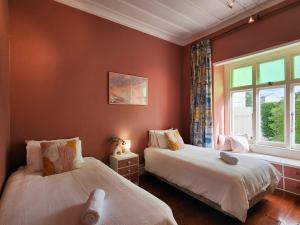 En eller flere senge i et værelse på Villa Hahei