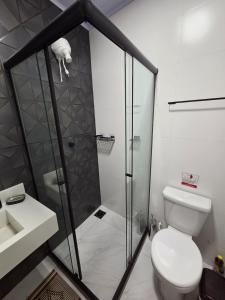 a bathroom with a shower and a toilet and a sink at Sua Estadia Angra - Casa de 2 Quartos no Centro de Angra in Angra dos Reis +17 photos