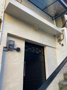 een zwarte deur aan de zijkant van een huis bij Sua Estadia Angra in Angra dos Reis +15 foto's