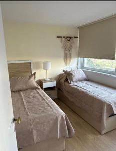 een slaapkamer met twee bedden en een raam bij Enfrente al mar Servicio de playa Limpieza diaria Estacionamiento Sábanas y toallas Gimnasio Recepción 24 hs A pasos del puerto y Gorlero in Punta del Este
