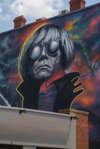 ein Wandgemälde eines Mannes mit Sonnenbrille im Gesicht in der Unterkunft Cozy KING Escape Central Free Parking in Pittsburgh