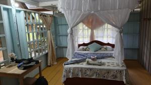 a bedroom with a canopy bed with a window at Hostal Ebenezer Macedonia in Macedonia +75 photos