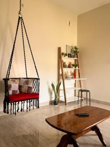 a swing in a room with a table and a chair at Payaringal House Botanical Garden White Town Promenade Beach in Pondicherry