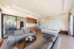 ein großes Wohnzimmer mit einem Bett und einer Couch in der Unterkunft D26 Nha Trang Hotel in Nha Trang