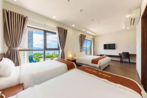 ein Hotelzimmer mit zwei Betten und einem Fernseher in der Unterkunft D26 Nha Trang Hotel in Nha Trang
