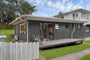 a small house with a porch and a fence at Henderson Oasis in Auckland