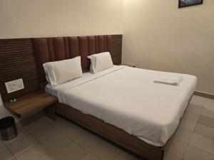 a bedroom with a large bed with white sheets and pillows at Hotel GT Galaxy in Chennai