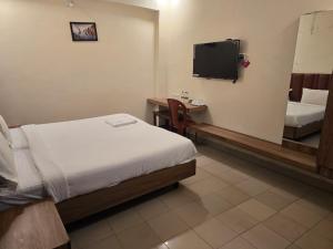 a hotel room with a bed and a tv at Hotel GT Galaxy in Chennai +3 photos
