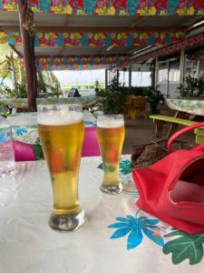 deux verres de bière posés sur une table dans l'établissement Punahere lodge Ohotu, à Rangiroa