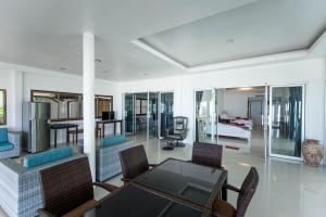 een woonkamer met een tafel en stoelen bij the ocean resort samui in Nathon Bay