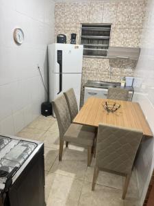een keuken met een houten tafel en een koelkast bij Refúgio à Beira Mar Na Praia da Tartaruga in Rio das Ostras