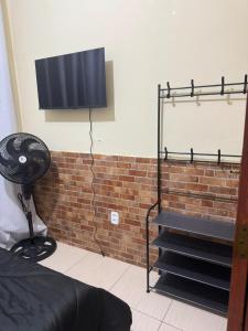 een slaapkamer met een ventilator en een bakstenen muur bij Refúgio à Beira Mar Na Praia da Tartaruga in Rio das Ostras
