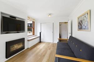 a living room with a couch and a fireplace at Lakeside Bliss Homestead with outdoor spa in Queenstown