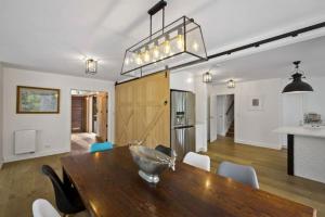 a kitchen and dining room with a wooden table and chairs at Lakeside Bliss Homestead with outdoor spa in Queenstown