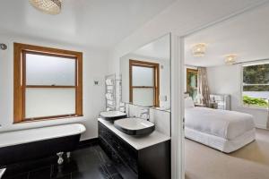 a bathroom with a bed and a sink and a tub at Lakeside Bliss Homestead with outdoor spa in Queenstown +14 photos