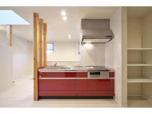 een keuken met een rode spoelbak en een fornuis bij Ippuku - Vacation STAY 17436 in Kanazawa