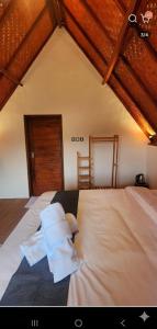 una camera da letto con un grande letto bianco e un soffitto in legno di Pondok Kanginan a Plaga