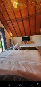 una persona sdraiata su un letto in una camera da letto di Pondok Kanginan a Plaga