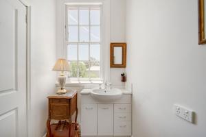 a white bathroom with a sink and a window at The Globe in Castlemaine +21 photos