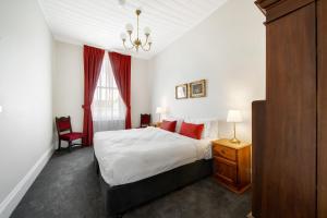 a bedroom with a large bed with red pillows at The Globe in Castlemaine