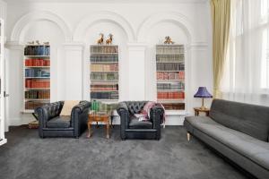 a living room with two couches and bookshelves at The Globe in Castlemaine