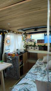 a bedroom in an rv with a bed and a table at Van a louer au pied des pistes 2 in Séez +1 photo