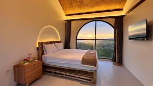 a bedroom with a bed and a large window at HappyNest Glamping and Villa Dieng in Garung
