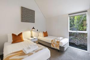 une chambre avec deux lits et une fenêtre dans l'établissement Panoramic Farmhouse theme with shared spa pool, à Queenstown