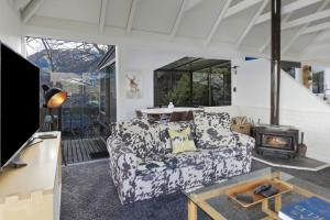 - un salon avec un canapé et un poêle à bois dans l'établissement Panoramic Farmhouse theme with shared spa pool, à Queenstown