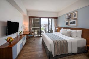ein Schlafzimmer mit Bett, Schreibtisch und Fernseher in der Unterkunft Rama Residence Padma in Legian + 47 Fotos