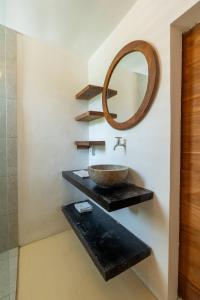 een badkamer met een wastafel en een spiegel bij Villa Tropical A in Uluwatu