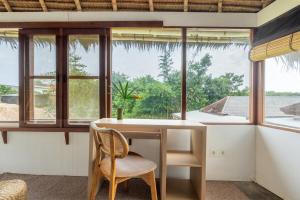 een kamer met een tafel en een aantal ramen bij Villa Tropical A in Uluwatu