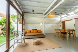 een slaapkamer met een bed, een tafel en stoelen bij Villa Tropical A in Uluwatu