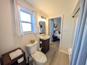 a bathroom with a toilet and a sink and a window at Modern Norwalk Retreat 2 King Suites Sunroom in Norwalk