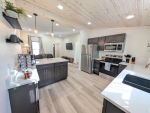 a large kitchen with wooden floors and stainless steel appliances at Modern Norwalk Retreat 2 King Suites Sunroom in Norwalk