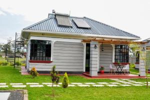 a small white house with a pitched roof at Mavana Cottages in Ol Pejeta Conservancy
