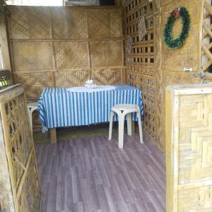 a table and stool in a room with a wreath at Shirley's Cottage - Pamilacan Island in Baclayon +30 photos