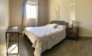 una camera da letto con un letto, un comò e una finestra di Departamentos Raices - Jardines del Lago a Mexicali
