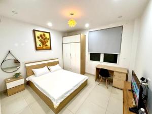 una camera da letto con un letto, una scrivania e una televisione di Phòng ngủ riêng khép kín a Nha Trang