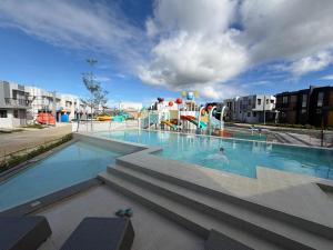 a pool with a water park with a person in it at Kaizen Urban Retreat - Elevate Your Stay in Calo