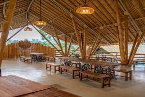 een grote kamer met tafels en banken in een gebouw bij Plenary Khao Kho in Ban Nong Chaeng