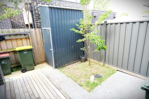 een kleine boom in een tuin naast een hek bij All you need for work, stay and relax in Melbourne +28 foto's