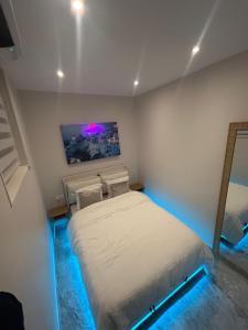 a bedroom with a bed in a room with blue lights at L&A Appartement in Montargis